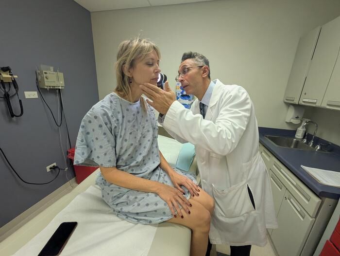 Dr. Pedram Gerami examines the skin of patient and melanoma survivor Heidi Tarr  (Source: Ben Schamisso / Northwestern University)