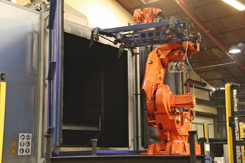 Bild 1: In der Strahlanlage befreit RHI seine stählernen Umlaufpaletten von Teerrückständen, die Handhabung übernimmt ein Roboter. (Bild: Itasse)