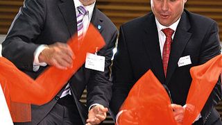 Mit dem symbolischen Durchtrennen eines Bandes eröffnen Horst Schneider, Oberbürgermeister der Stadt Offenbach (l.), und Uwe Geissinger, CEO Dematic Central Europe, das neue Tech-Center am Standort Offenbach. Bild: Maienschein (Archiv: Vogel Business Media)