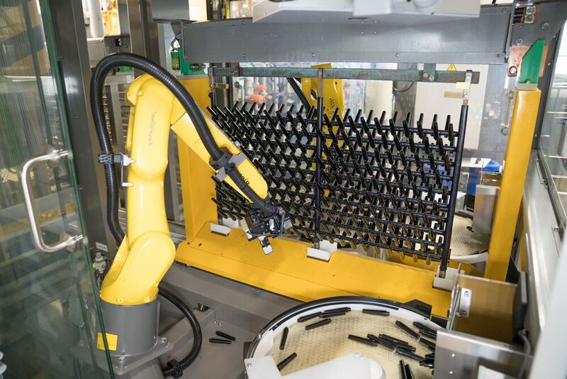 Der Roboterarm bestückt die Haken vollautomatisch, bevor das Gestell ins Galvanikbad getaucht wird. (Bild: Baumer)