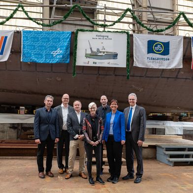 Feiern die Kiellegung von Modularis: Manuel Ortuño, Lloyd’s Register, Frank Mallon, FSG Shipyard, Thorsten Rönner, Lloyd Werft Bremerhaven, Prof. Dr.-Ing. Anke Kaysser-Pyzalla, DLR, Prof. Sören Ehlers,  DLR-Institut für Maritime Technologien und Antriebssysteme, Prof. Meike Jipp, DLR, Prof. Karsten Lemmer, DLR (vlnr). (Bild: DLR Fotomedien KP)