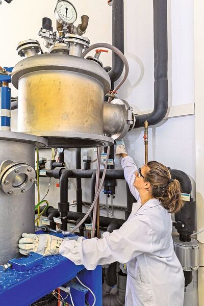 Eva Maria Heppke öffnet den Kristallzüchtungsbehälter, in den der befüllte Schmelztiegel eingesetzt wird. (TU Berlin/PR/Felix Noak)