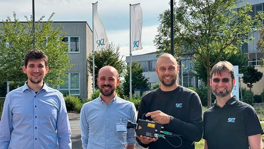 Dem SKZ in Würzburg wurde nun ein Kameratomografiesystem von Tenta Vision übergeben, das vor allem Composites berührunglos auf ihre Qualität hin prüfen kann. Von links: Petry und Rune Monzel von Tenta Vision, Luis Wachter (mit dem System) und Christian Kolb, vom SKZ.(Bild:  SKZ)