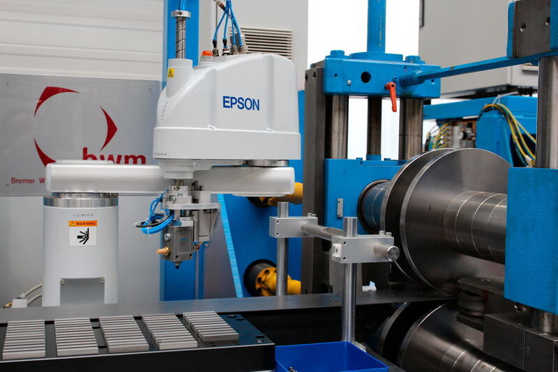 Forschungsprojekt zum Fügen mittels Walzprofilieren am PTU: Ein Roboter positioniert Bauteile in vorgestanzte Löcher des Blechbandes. Diese Bauteile werden dann durch die Spannungen, die beim Walzprofilieren entstehen, festgeklemmt. (Itasse)