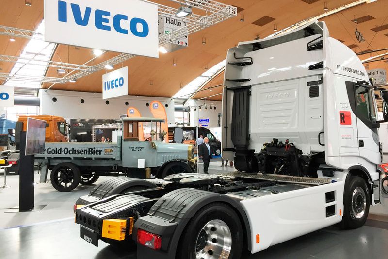 100 Jahre liegen zwischen diesen beiden Lkw. Im Jahre 1917 rollte der erste Magirus auf die Straße (im Bildhintergrund). Erst im Jahr zuvor hatte Oberingenieur Heinrch Buschmann bei der C. D. Magirus AG in Ulm mit der Konstruktion des Drei-Tonnen-Transporters begonnen. Der 2c war der erste Lkw, der auf der Basis metrischer Maße gebaut wurde. (Faust / »kfz-betrieb«)