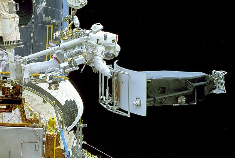 L'astronaute Jeffrey Hoffman manipule l'instrument Wide Field-Planetary Camera-1 (WF-PC1) qui vient d'être retiré du télescope spatial Hubble pour être remplacé par WF-PC2 durant la mission STS-61. (Image: Nasa)