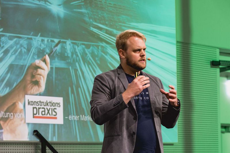 Jan Seyler, Leiter KI und Regelungstechnik, Forschung und Innovation bei der Festo SE & Co. KG, eröffnete das Programm mit seinem Vortrag zu KI im Engineering und betonte, wie effiizient heute der Umgang mit Wissen ist und welches Potenzial daraus entstehen kann, wenn Mensch und Maschine kollaborativ zusammenarbeiten.  (Bild: Stefan Bausewein/VCG)