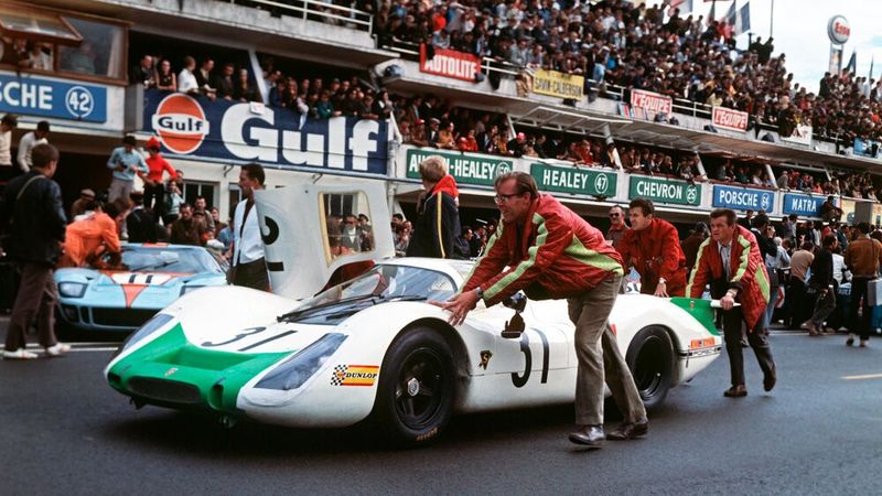 Peter Falk mit einem Porsche 908 Langheck-Coupé 1968 in Le Mans, 1968. Den Rennwagen bzw. Sport-Prototyp der Gruppe 6 hatte Porsche für die Sportwagen-Weltmeisterschaft konstruiert. Dessen luftgekühlte Boxer-Saugmotor mit 8 Zylindern leistete 257 kW (350 PS) bei einer Drehzahl von 8.400/min, später bis zu 271 kW (370 PS). (Bild: Porsche)