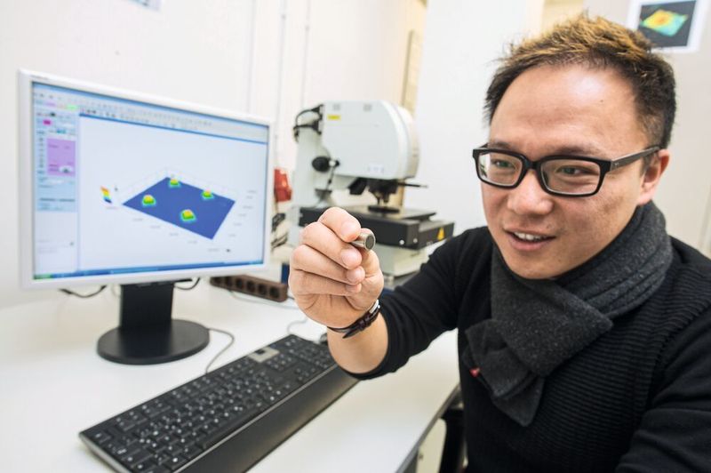 Dr. Shiqi Fang aus dem Forschungsteam von Prof. Dirk Bähre von der Universität Saarland zeigt eines der maßgeschneiderten Schleifwerkzeuge mit mikrostrukturierter Oberfläche: in diesem Fall sind es die im Aufmacher gezeigten strahlenförmig angeordnete Noppen. (O. Dietze)