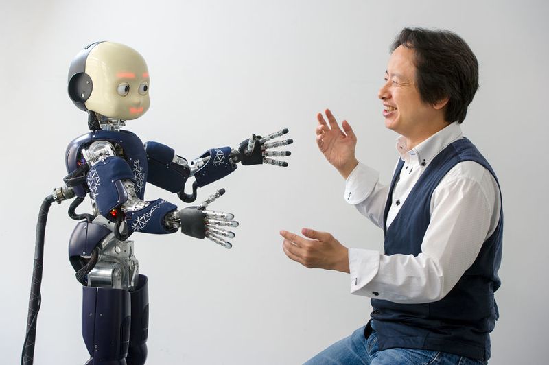 Prof. Gordon Cheng, Leiter des Instituts für Kognitive Systeme an der Technischen Universität München, mit einem humanoiden Roboter. (© Andreas Heddergott / TUM)
