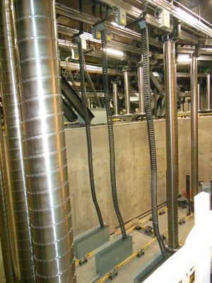 Bild 17: Das Hebesystem „Spiralift“ wird unter anderem weltweit in Theatern und Konzerthäusern genutzt, um Teile der Bühne auf- und abzufahren. Da der Platz unter der Bühne sehr begrenzt ist und Strecken von mehr als 9 m zurückgelegt werden, müssen die Daten- und Stromkabel sicher geführt werden. Das wird durch igus Zick-Zack e-ketten erreicht, die platzsparend in schmalen Metallbehältern untergebracht sind. (Bild: Gala Systems Inc.)