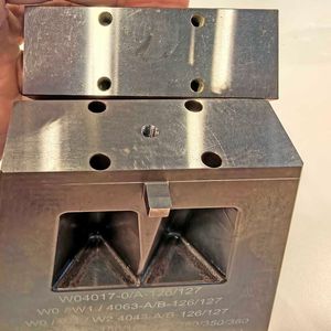 Die gehärteten, lediglich einseitig plangeschliffenen und mit Gewindebohrungen versehenen Rohlinge werden mit vier Schrauben auf dem selbst entwickelten Werkstückträger fixiert und ermöglichen so eine effektive, kollisionsfreie Fünfseitenbearbeitung.(Bild:  Klaus Vollrath)