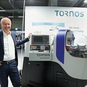 Rolph Lucassen (Head of Marketing & Communications, Tornos) neben der Swiss-Nano, die auf kleinstem Raum enormes zerspanungstechnisches Potenzial bietet.(Bild:  Matthias Böhm)