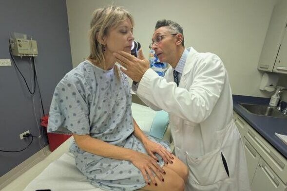 Dr. Pedram Gerami examines the skin of patient and melanoma survivor Heidi Tarr (Source:  Ben Schamisso / Northwestern University)