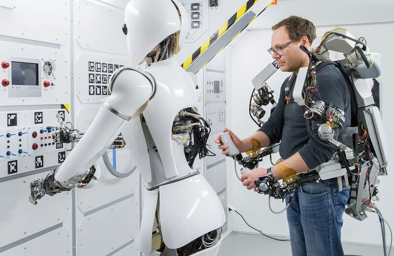 Ein Operator steuert den humanoiden Roboter Aila mithilfe eines Oberkörper-Exoskeletts in einem Nachbau der ISS am DFKI. (DFKI GmbH/Annemarie Popp)