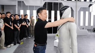 He Xiaopeng hängt dem Humanoiden „IRON“ einen Mitarbeiterausweis um den Hals, als Teil des Teams. (Bild: Xpeng)
