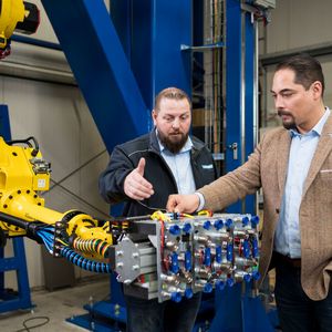 Rechtzeitig wurde auch die Roboter-Automatisierung für das Be- und Entladen der Trubend Center 7020 in Betrieb genommen. „Das bringt zusätzlich Tempo in den Produktionsprozess“, sagt Michael Kuipers (rechts) und Karsten Hanenkamp ergänzt: „Die Greifer legen Fertigteile auf bereitstehende Paletten zum Weitertransport in die Schweißerei.“(Bild:  Trumpf)