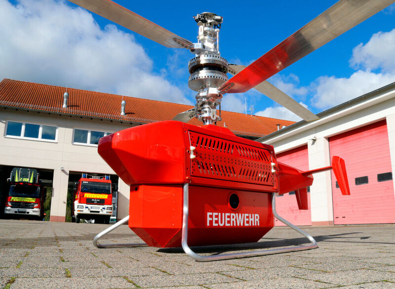 Hier das feuerrote Fluglöschmobil! Doch diese Drohne ist nur eine aus einem Schwarm von Feuerlöschdrohnen, der in Zukunft die Waldbrandbekämpfung flexibler, sicherer und günstiger erledigen soll. Ein smart Manufacturer, ein Start-up und eine Hochschule sind die Väter.