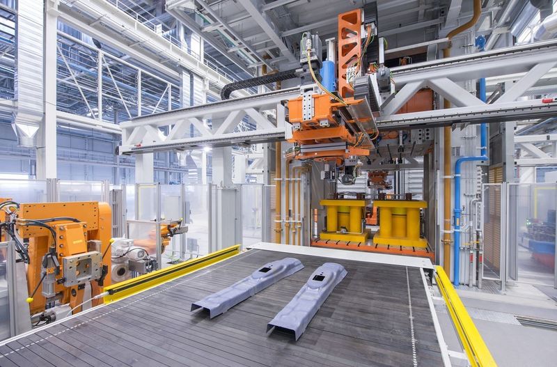 Das Auslaufband mit den fertig gepressten Halbteilen, Entnahme des Halbteiles aus der Presse durch den Feeder und Ablegen auf dem Auslaufband. (Bild: Audi)