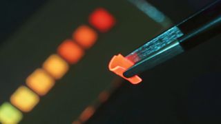 Der neu entwickelte Solarkollektor bei Bestrahlung mit blauem LED-Licht: Das Polymer-Material ist so flexibel, dass es sich mit einer Pinzette biegen lässt.  (Bild: Empa)