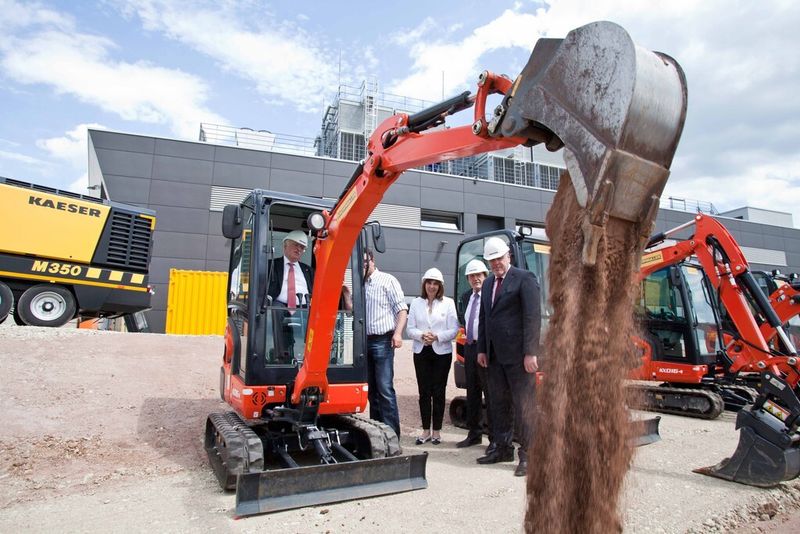 Nach dem klassischen Spatenstich kam die technische Variante mit Minibagger als „Spatenstich“ zum Einsatz. Im Bild Thomas Kaeser,  Alf Luthardt (Baufirma), Tina-Maria Vlantoussi-Kaeser, IHK-Präsident Friedrich Herdan und Oberbürgermeistern Norbert Tessmer. (Bild: Kaeser Kompressoren)