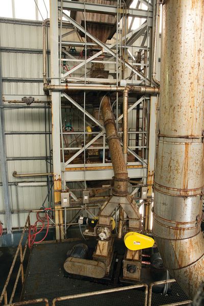 The surge hopper (top) meters CaCl2 pellets, which flow through two intake chutes to the cutters. (Munson)