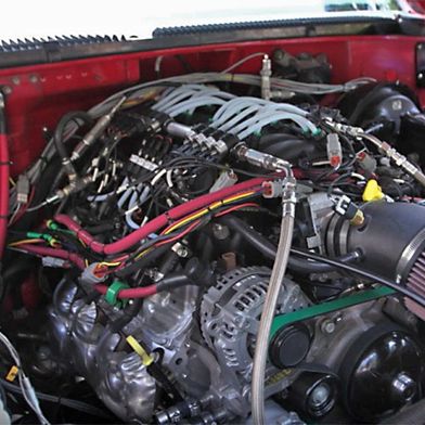 Der Motorinnenraum des Fahrzeuges; links und rechts von dem mit Ammoniak betriebenen Motor sind die beiden Crackreaktoren (umgeben von weißem Isolationsmaterial) zu sehen. (Bild: First Ammonia Motors)