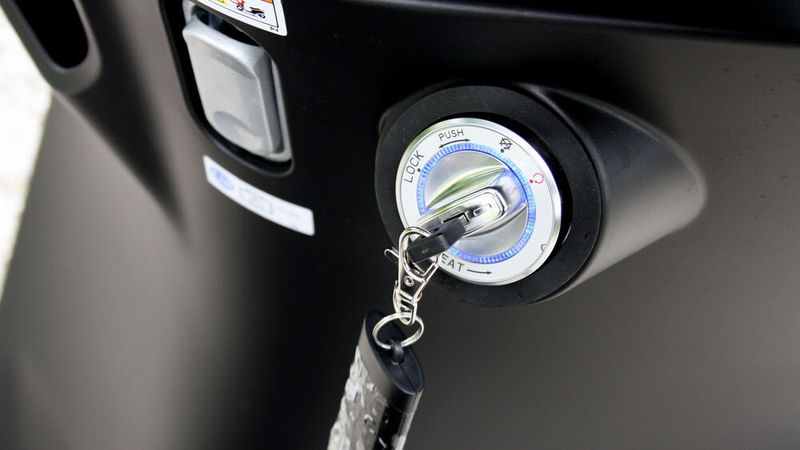 Im Beinschild gibt es ein „Zünd“-Schloss mit Leuchtring. Der Schlüssel kann in der Tasche des Fahrers bleiben, wenn er das Fahrzeug mit dem Signalgeber per Knopfdruck entriegelt. (Bild: sp-x/Mario Hommen)