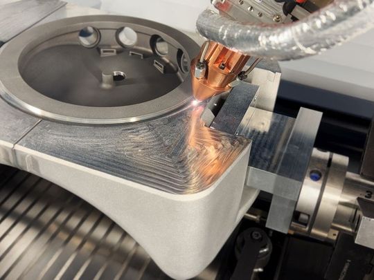 Beim LMD-Verfahren schmilzt ein Laser die Oberfläche, während Metallpulver zugeführt wird.(Bild:  Toolcraft)