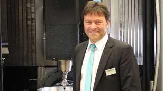 Hurco-Geschäftsführer Michael Auer vor dem neuen Fünf-Achs-Bearbeitungszentrum, das speziell für den europäischen Markt entwickelt wurde. (Bild: Kroh)