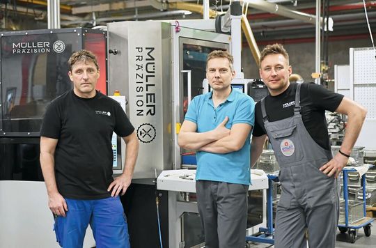 Erfolgreiche Partnerschaft: Müller Präzision Schleifexperten vor der hochautonomen Spitzenlosschleifmaschine «Cube 350».(Bild:  Müller Präzision)