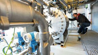 Marc-Simon Löffler, Leiter des Fachgebiets Regenerative Energieträger und Verfahren am ZSW, vor einem Elektrolyseblock.  (picture alliance/dpa )