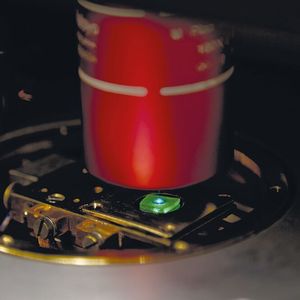 Eine Probe mit mehreren grün leuchtenden Perowskit-Quantenpunkten, die von einem blauen Laser angeregt werden. 