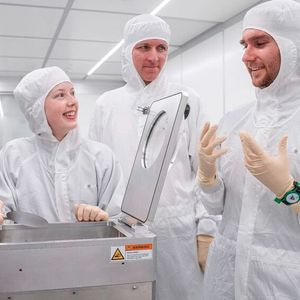 Lauren Riddiford, Aleš Hrabec et Jeffrey Brock (de gauche à droite) dans la salle blanche du Park Innovaare, juste à côté du PSI. C'est ici que sont créées les nouvelles structures magnétiques, qui sont modifiées de manière ciblée au laser. (Source :  Institut Paul Scherrer PSI/ Mahir Dzambegovic)