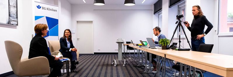 Hinter den Kulissen: Christine Krumm (fbmt) und Dubravka Maljevic (BG Kliniken) begrüßten die Teilnehmer aus einem eigens hergerichteten kleinen Studio in einem Berliner Hotel. Hinter den Kulissen: Christine Krumm (fbmt) und Dubravka Maljevic (BG Kliniken) begrüßten die Teilnehmer aus einem eigens hergerichteten kleinen Studio in einem Berliner Hotel.