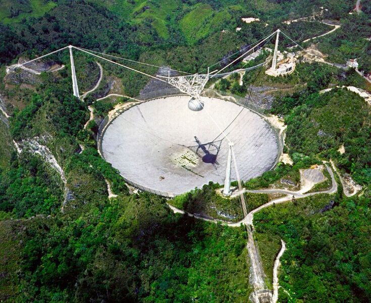 Schüssel im Grünen: Das Radioteleskop Arecibo in Puerto Rico besitzt einen Durchmesser von 305 Metern und lauscht nach Signalen von Pulsaren. Einstein@Home kann sie aufspüren und verwandelt damit den heimischen PC, das Smartphone oder das Tablet in ein wertvolles Werkzeug für die Wissenschaft. (NAIC - Arecibo Observatory)
