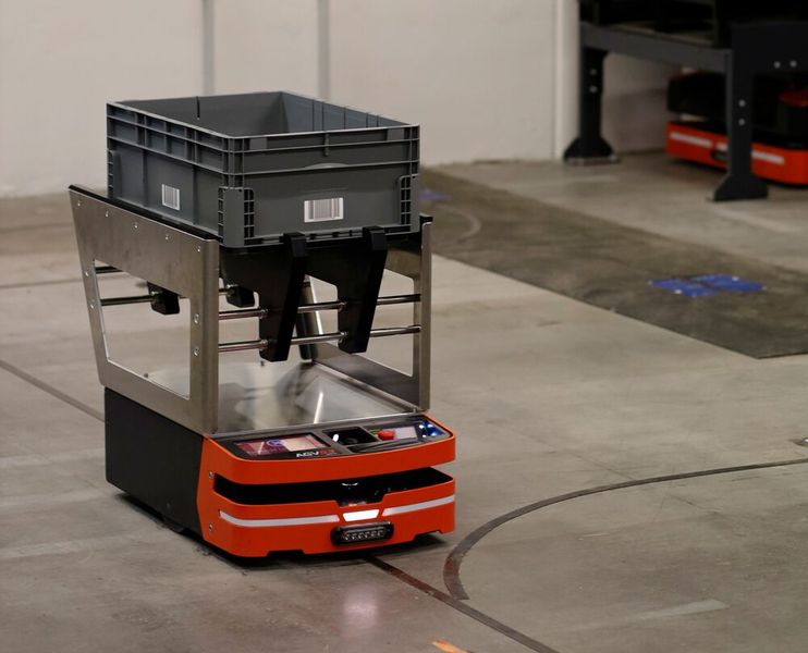 Ein anderes der 60 Safelog-AGV im Lager von Dresselhaus beim Transport eines Behälters. (Bild: Safelog)