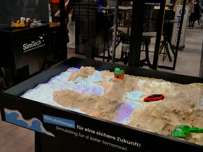 Ein interaktiver Sandkasten des Exzellenzclusters „Daten-Integrierte Simulationswissenschaft“ (Simtech) der Universität Stuttgart lädt dazu ein, Wellenhöhe oder Meeresspiegel zu verändern. Die Simulation passt sich dann entsprechend an und stellt die Auswirkungen der Änderungen dar.  (Bild: Sandro Kipar/VCG)