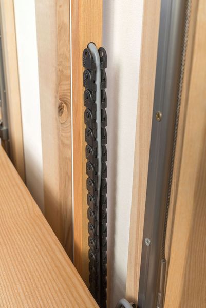 Strom und – bei Bedarf – Daten werden über eine Igus-Energiekette in der Arbeitsplatte übertragen. (Thomas Wozak / Holzbureau GmbH)