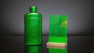 Gelaserte Flasche und Kunststoffplättchen mit hologrammähnlicher Markierung – erzeugt mit dem neuen Laseradditiv von Finke Colors in transparentem Polymer, ohne Veränderung der Oberfläche. (Bild: Finke Colors)
