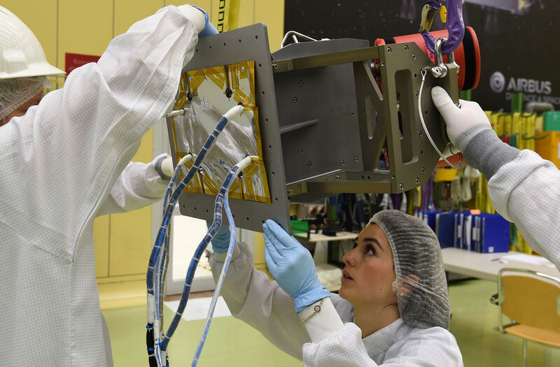 Zwei Ingenieurinnen kleben Thermalfolie  an eine Box, die zum Servicemodul der 