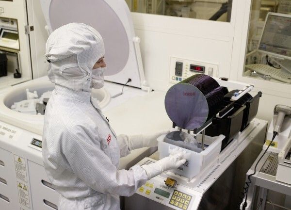 Automotive Electronics: In der neuen Halbleiterfertigung von Bosch entstehen integrierte Schaltkreise (IC) und mikromechanische Bauelemente (MEMS). Ausgangsmaterial sind dünne Siliziumscheiben, so genannte Wafer, mit einem Durchmesser von 200 Millimetern. Im Bild: Eine Mitarbeiterin belädt eine Reinigungsanlage für Siliziumwafer. (Bild: Bosch)