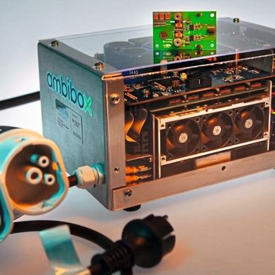 Demonstrator eines bidirektionalen einphasigen 3-kW-DC-Ladegeräts mit GaN-Leistungselektronik. Das leistungselektronische Modul (oben) haben Forschende des Fraunhofer IAF auf Basis des Leistungshalbleiters Galliumnitrid (GaN) und alternativen isolierenden Substraten entwickelt. Die Realisierung des Demonstrators sowie die Integration des Moduls erfolgte durch den GaN4EmoBiL-Projektpartner Ambibox. (Bild: Fraunhofer IAF)