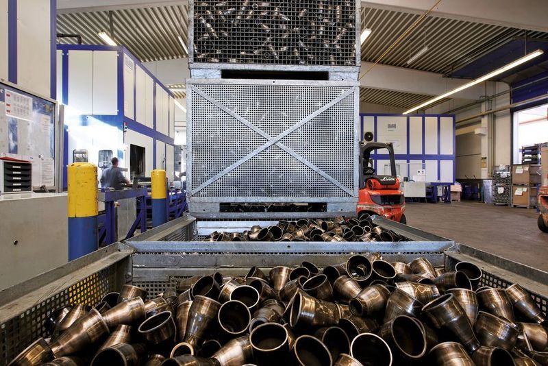 Anlagenbeschickung: Konen werden als Schüttgut in Gitterboxen den Reinigungsanlagen zugeführt. Je nach Bauteil und Verschmutzung ist auch ein Positionieren (Setzen) in Gitterboxen möglich. Bild: Dürr Ecoclean (Archiv: Vogel Business Media)