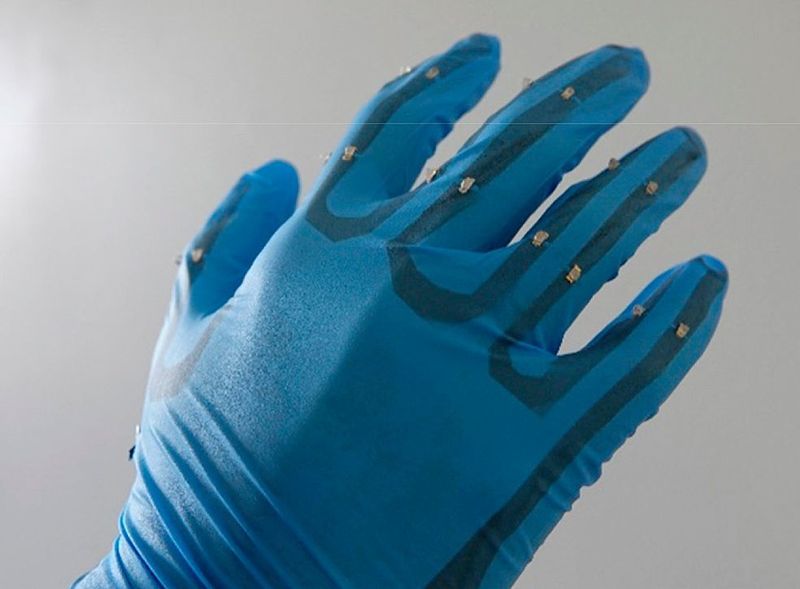 Ein Nitril-Handschuh ist mit dem transpartenten Nanogenertor ausgestattet. Auf der Rückseite sind 16 blaue LEDs in Reihe geschalten. Die erzeugte Ausgangsleistung von 8 W/m² reicht aus, um die LEDs zum Leuchten zu bringen. (Nagoya University)
