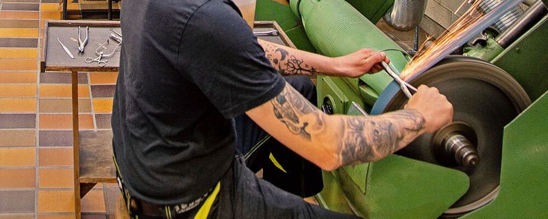 Die Auszubildenden der Tuttlinger Berufsschule erlernen viele unterschiedliche Verfahren der Oberflächenbearbeitung, darunter auch das Schleifen an der Bandschleifmaschine. Mit dem Esta-Nassabscheider können die anfallenden Schleifstäube und Funkenflug mittels Wasserabscheidetechnologie schnell unschädlich gemacht werden.(Bild:  Esta)