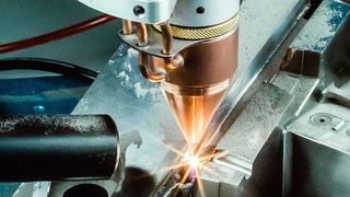 Beim DMD Verfahren wird Metallpulver aus einer Pulverdüse koaxial zum Laser auf eine bestehende Oberfläche aufgetragen. (O.R. Lasertechnologie GmbH)