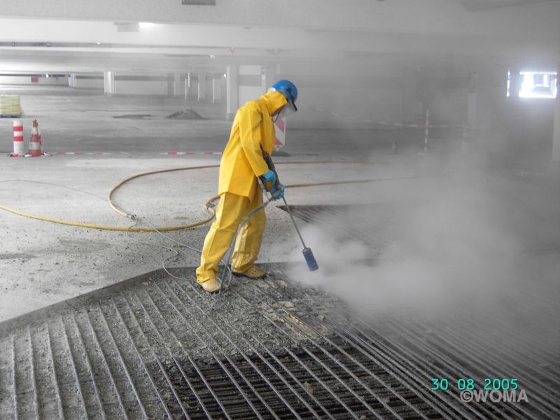 Achtung – so sollte es nicht gemacht werden! Der Arbeiter trägt lediglich einen Wasserschutzanzug, der nicht gegen Höchstdruckeinwirkung schützt, zudem fehlt der Spritzschutz an der Düse. Außerdem steht der Arbeiter auf einem Kabel – Stolpergefahr droht! (Bild: Woma)