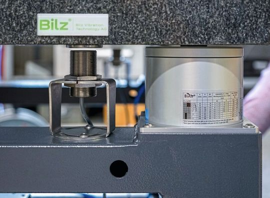 On the granite plate (top) stands a machine or testing system that is to be decoupled from vibrations. The inductive distance sensor (middle) continuously measures the distance to the granite plate (the target is a fixed steel disc). Supplied with these values, the controller quickly and precisely adjusts the level of the air spring (right).(Image:  Baumer)