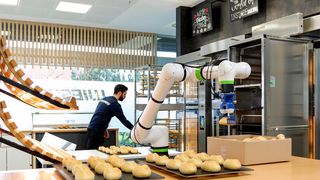 Der Cobot Bakisto holt die entsprechend mit Tiefkühl-Backwaren bestückten Backbleche aus der Kühlung und schiebt diese in den Transportwagen, der auf Schienen vor dem vorgeheizten Ofen platziert wird. Dann kann gebacken werden. (Bild: Fanuc Deutschland)